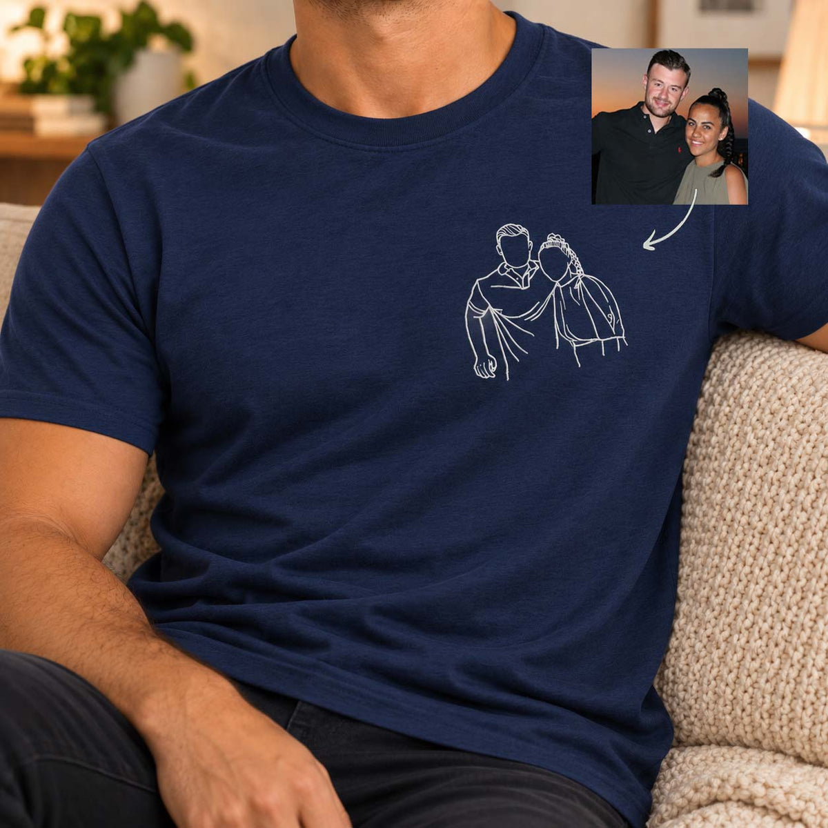 A man wearing a navy blue t-shirt with a white line art graphic of a couple on the chest. An inset image in the top right corner shows the couple whose portrait is drawn on the shirt, with an arrow pointing from the photo to the graphic.